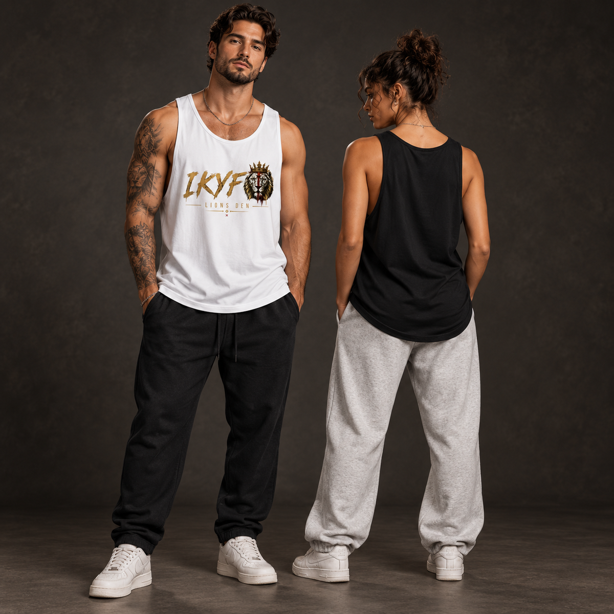 Two models wearing the Lions Den IKYF Crowned Lion loose tank in white and black, shown from the front and blank back