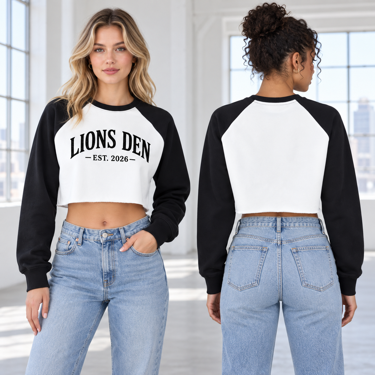Two women model the Lions Den EST. 2026 black-and-white color-block cropped sweatshirt, shown from the front and blank back.