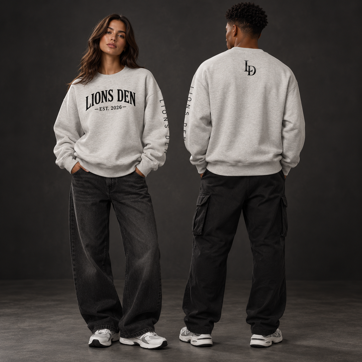 Two models wearing the heather-gray Lions Den EST. 2026 monogram fleece crewneck, shown from the front, sleeve, and back