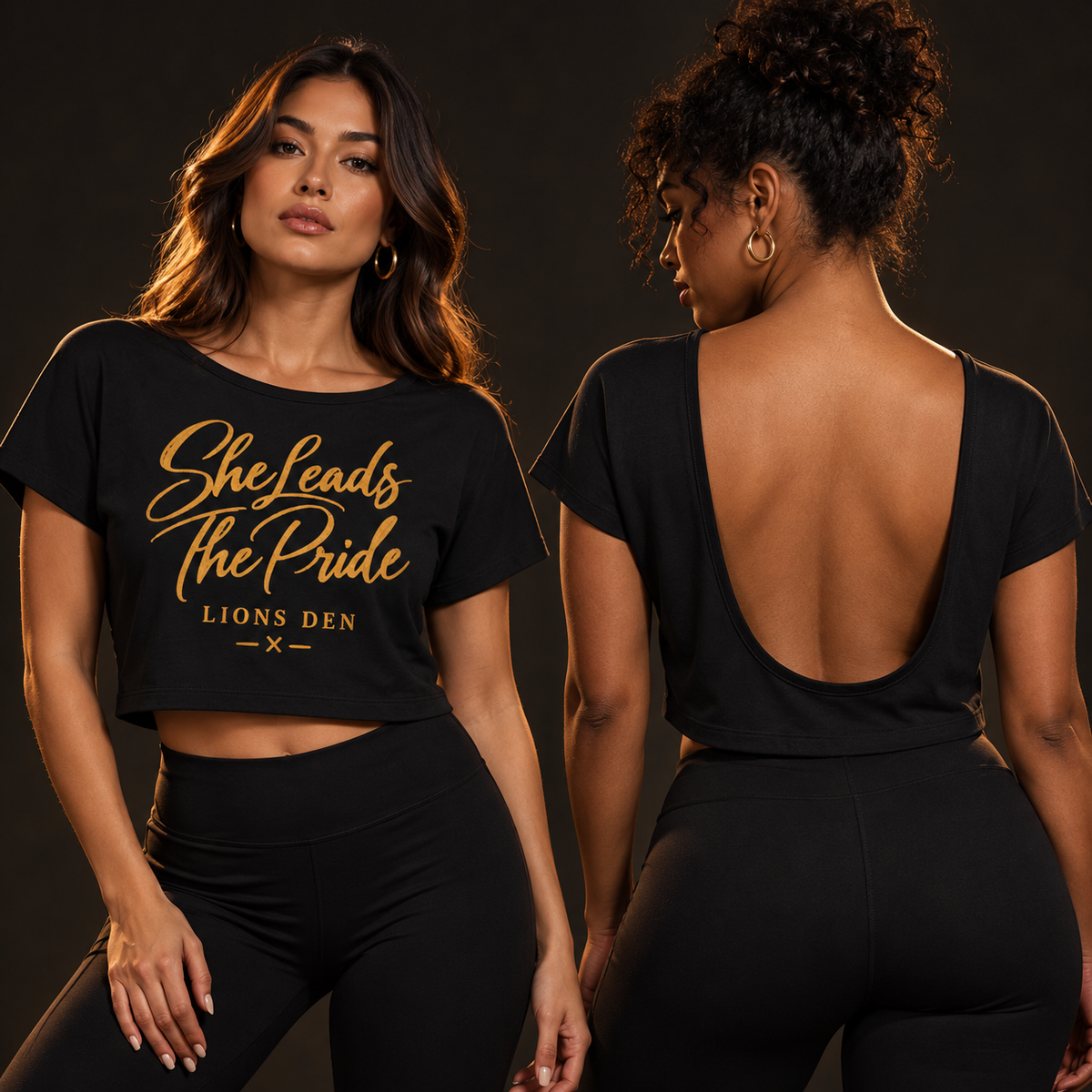Two women modeling the black Lions Den She Leads The Pride open-back tee, showing the front script and deep open-back construction